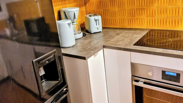 A compact kitchen with a refrigerator, a toaster, and a dishwasher. - city-centre apartment close to historic sites and shops (Nîmes)