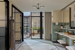 Suite junior, terraza, en esquina | Baño | Cabezal de ducha tipo lluvia y artículos de higiene personal de diseño