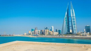 A coastal cityscape with modern skyscrapers, including a distinctive twin tower structure. - Mirador Hotel (Manama)