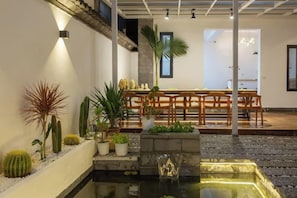 A dining area with a table and chairs, a small water feature, and various plants. - Dali Ancient City Bantian Homestay (Dali Ancient City Branch) (Dali)