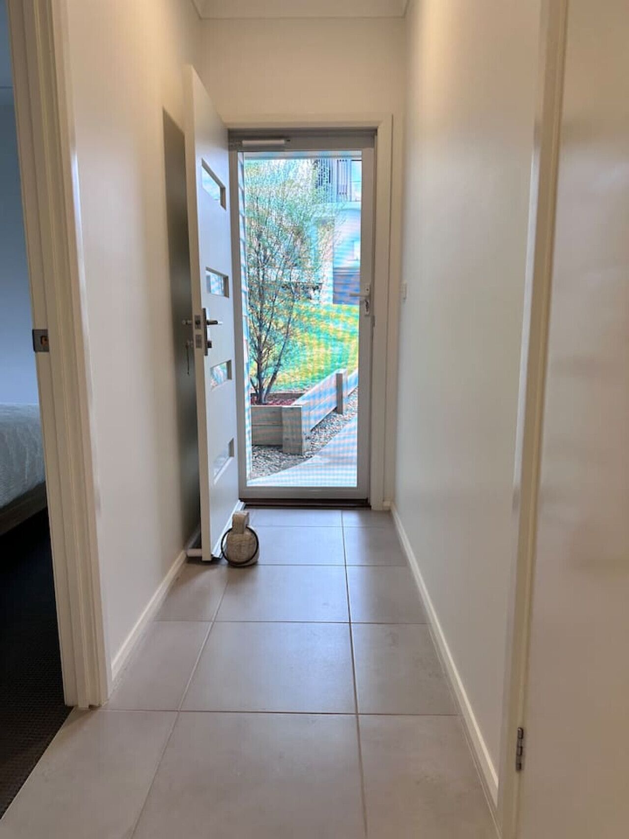 Ein schmaler Flur mit einer Tür zu einem Balkon.