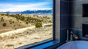 A bathroom with a large window offering a view of a mountainous landscape. - Moonrise Ridge, a Luxury Mountain Home set in Paradise Valley (Emigrant)