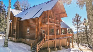 A log cabin with a balcony and a staircase leading to the entrance. - Custom high-end 3 bedroom log cabin sleeps 12. Located on the ski hill! (Angel Fire)