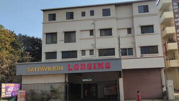 Un edificio de varios pisos con un cartel que dice 'Sai Pavilion Lodging' y una puerta de garaje cerrada.