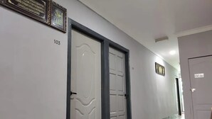 A hallway with two doors, one marked as '103' and another with a 'STAFF ONLY' sign. - Confidence Motel (Langkawi)