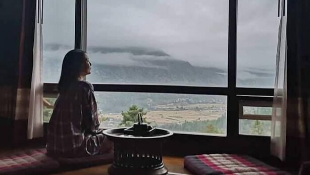 A room with large windows, a central table, and a view of a landscape. - Haven Resort and Spa (Paro)