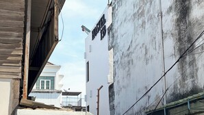 A building with a sign reading 'HOSTEL' and a visible window with a balcony. - Hostel 159 (Bangkok)