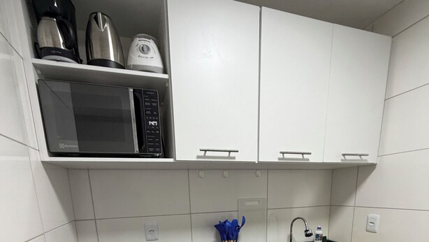 A modern kitchen with white cabinets, a black countertop, and a compact dishwasher. - AmazHost - Blue house ideal for couples with Wi-Fi (Belém)