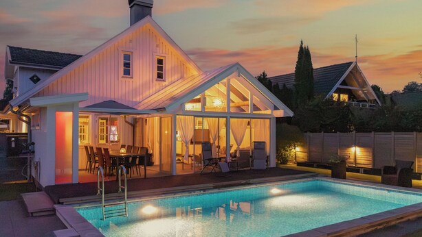 A modern house with a swimming pool, large windows, and a dining area. - Skreanäs by Interhome (Falkenberg)