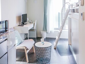 A modern hotel room with a desk, chair, and a round table with a coffee cup. - URBANAGE Takadanobaba (Tokyo)
