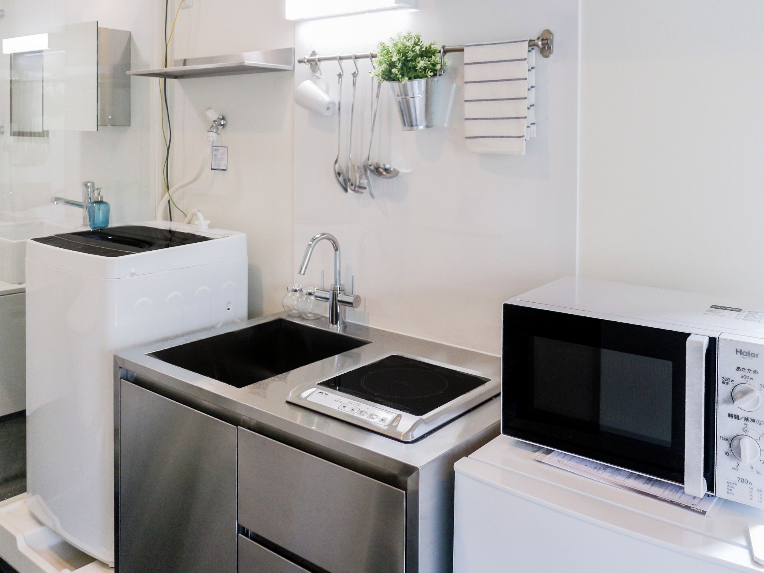 A modern kitchen with stainless steel appliances, a double sink, and a microwave.