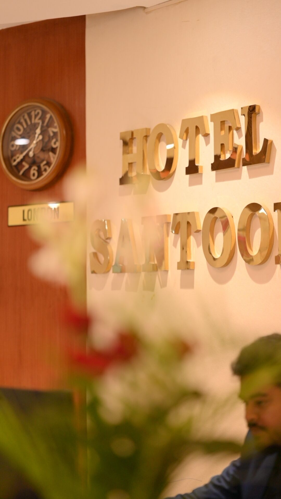 A wall with the words "HOTEL SANTO" and a clock.