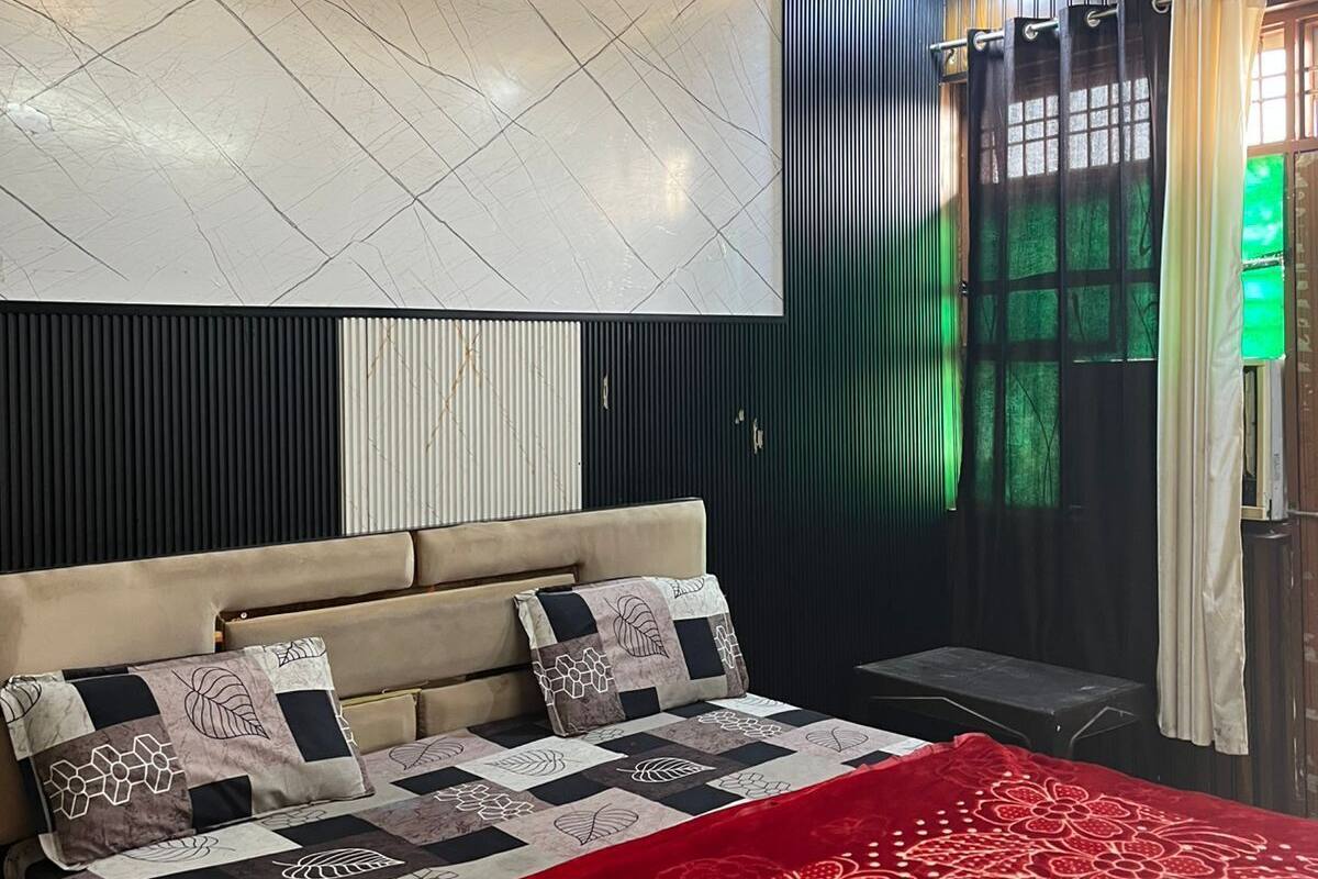 Une chambre moderne avec un grand lit, un ventilateur de plafond et une vue sur la verdure environnante.