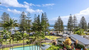 A campground with RVs, a swimming pool, and a view of the ocean. - Tasman Towers Unit 8 (Port Macquarie)