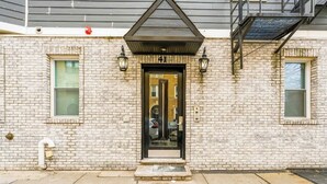 A brick building with a black door, numbered 41, and two windows on either side. - Modern Apartment w/ Parking & Fast NYC PATH Access (Jersey City)