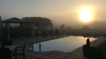 Een buitenzwembad en ligstoelen