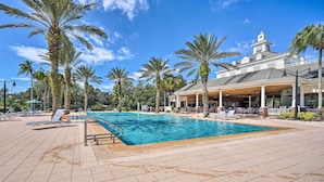 Une piscine avec des chaises longues et des palmiers.