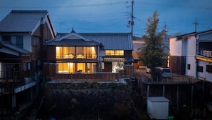 A traditional Japanese house with a wooden deck, a car parked outside, and a small shed in the yard. - Oyado Satsuki Nara Gojo Shinmachi (Gojo)