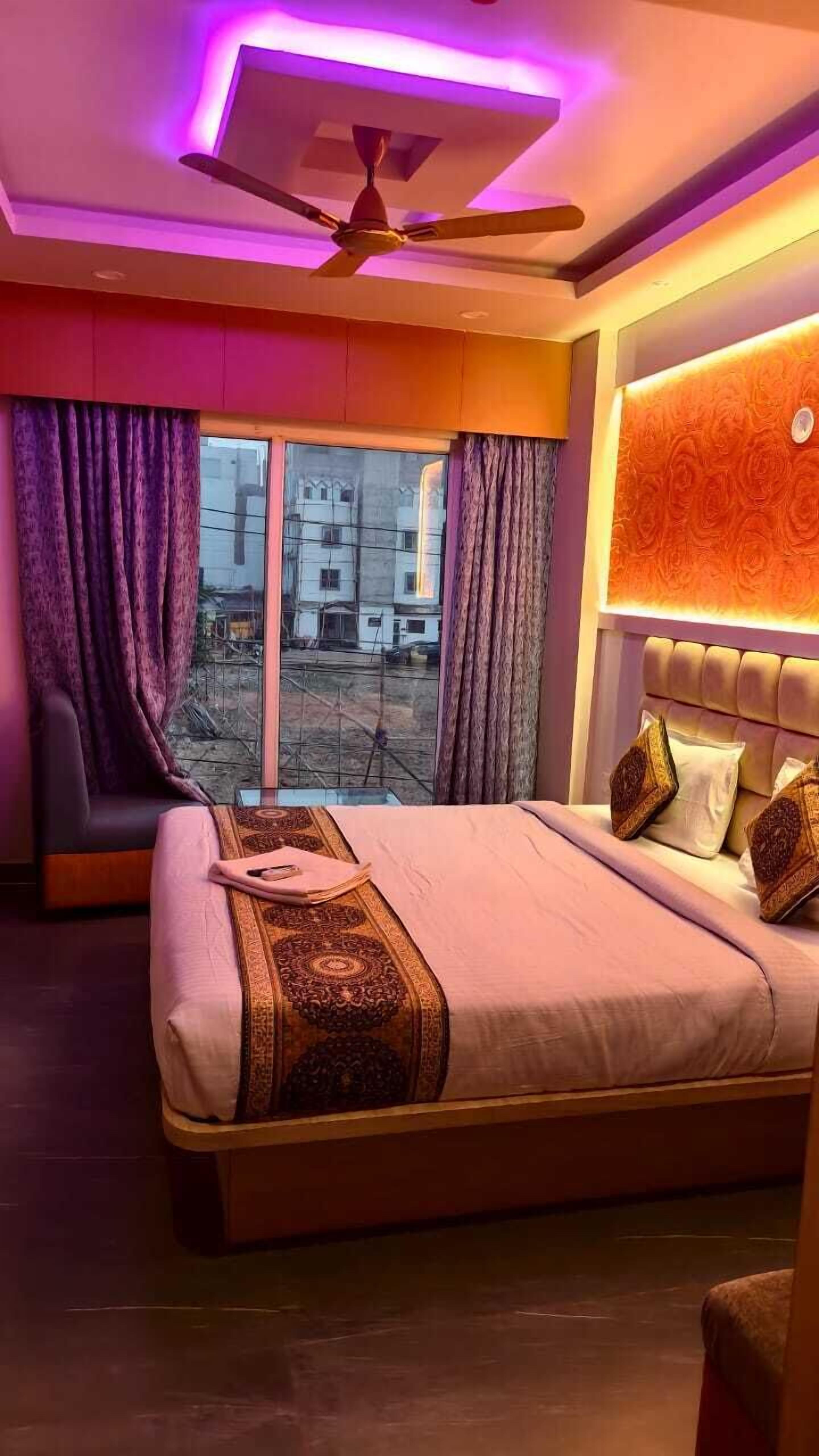 Ein Schlafzimmer mit Bett, Deckenventilator und Blick ins Freie.