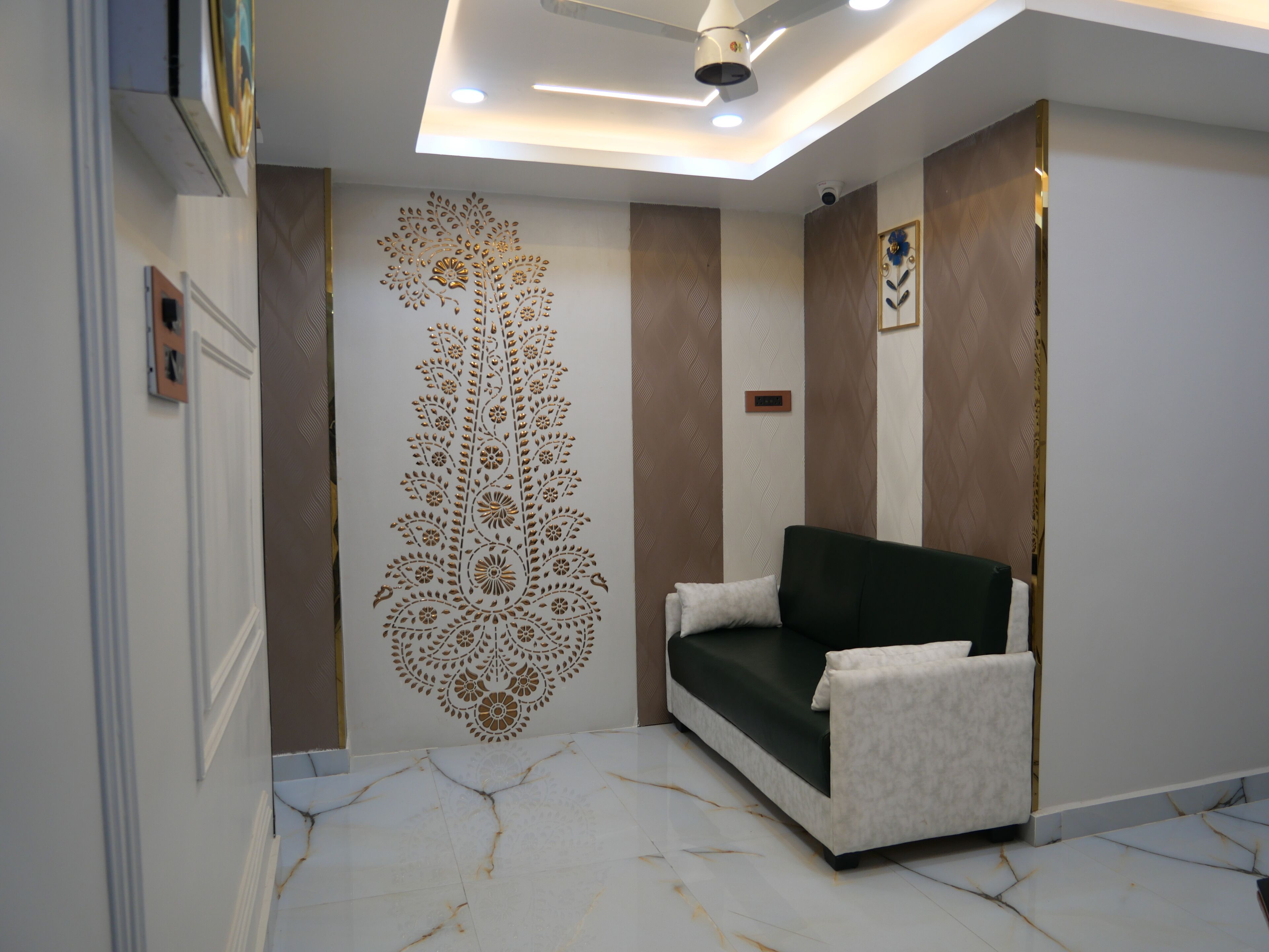 Un intérieur moderne avec un canapé, un mur à motifs et des luminaires au plafond.