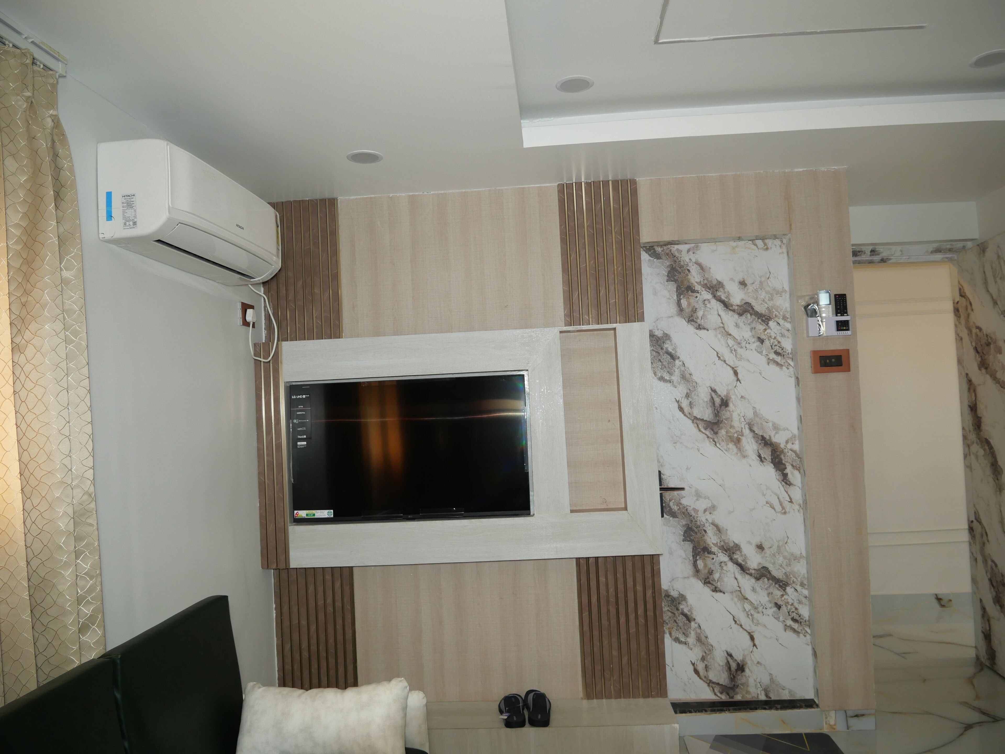 A modern living room with a flat-screen TV mounted on a wall with a wooden panel design.