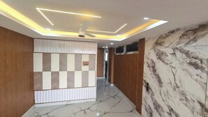 Un corridoio con una ventola a soffitto, illuminazione a incasso e pavimento in marmo.