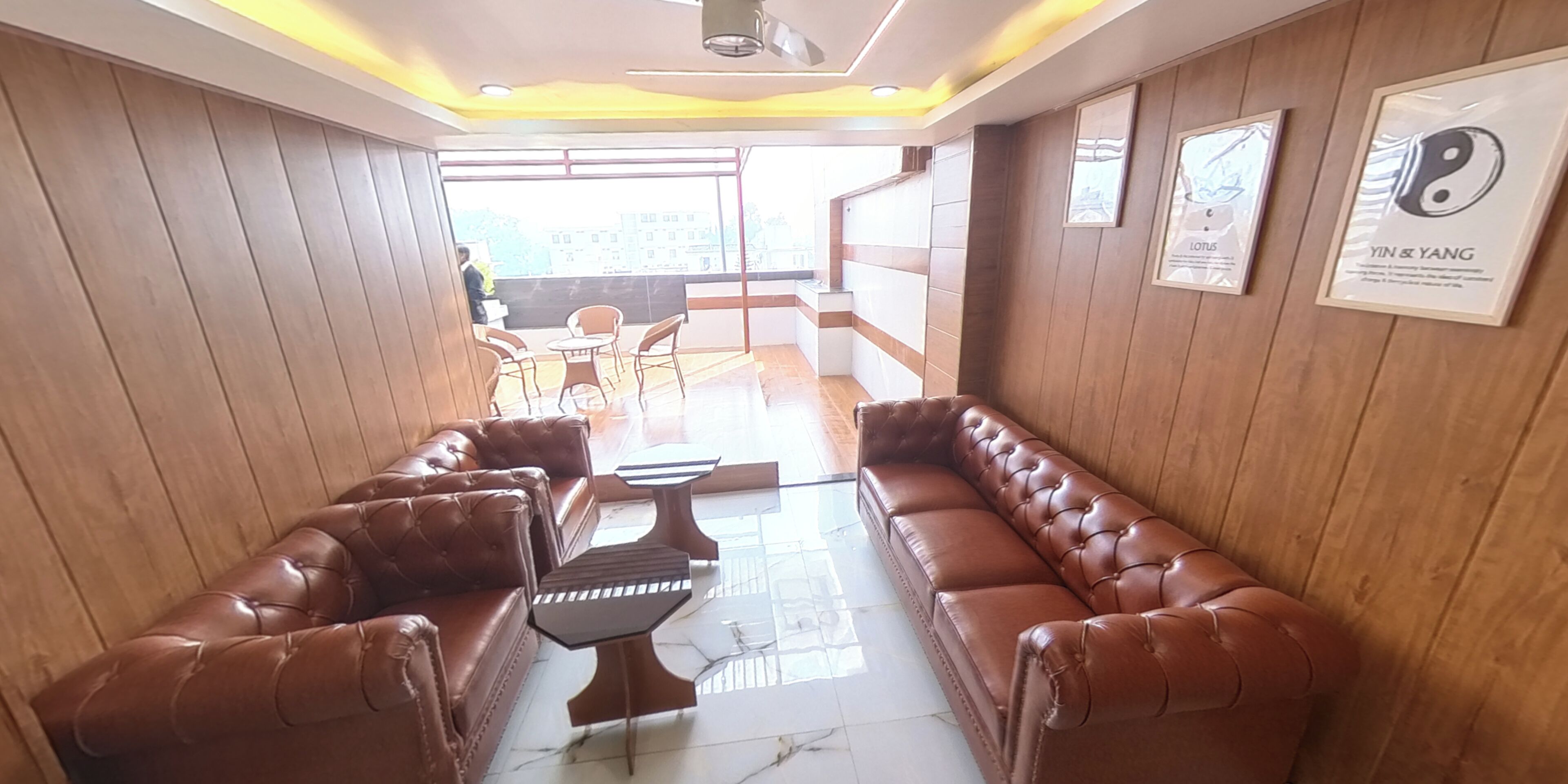 A lobby with leather sofas, a coffee table, and framed artwork on the walls.