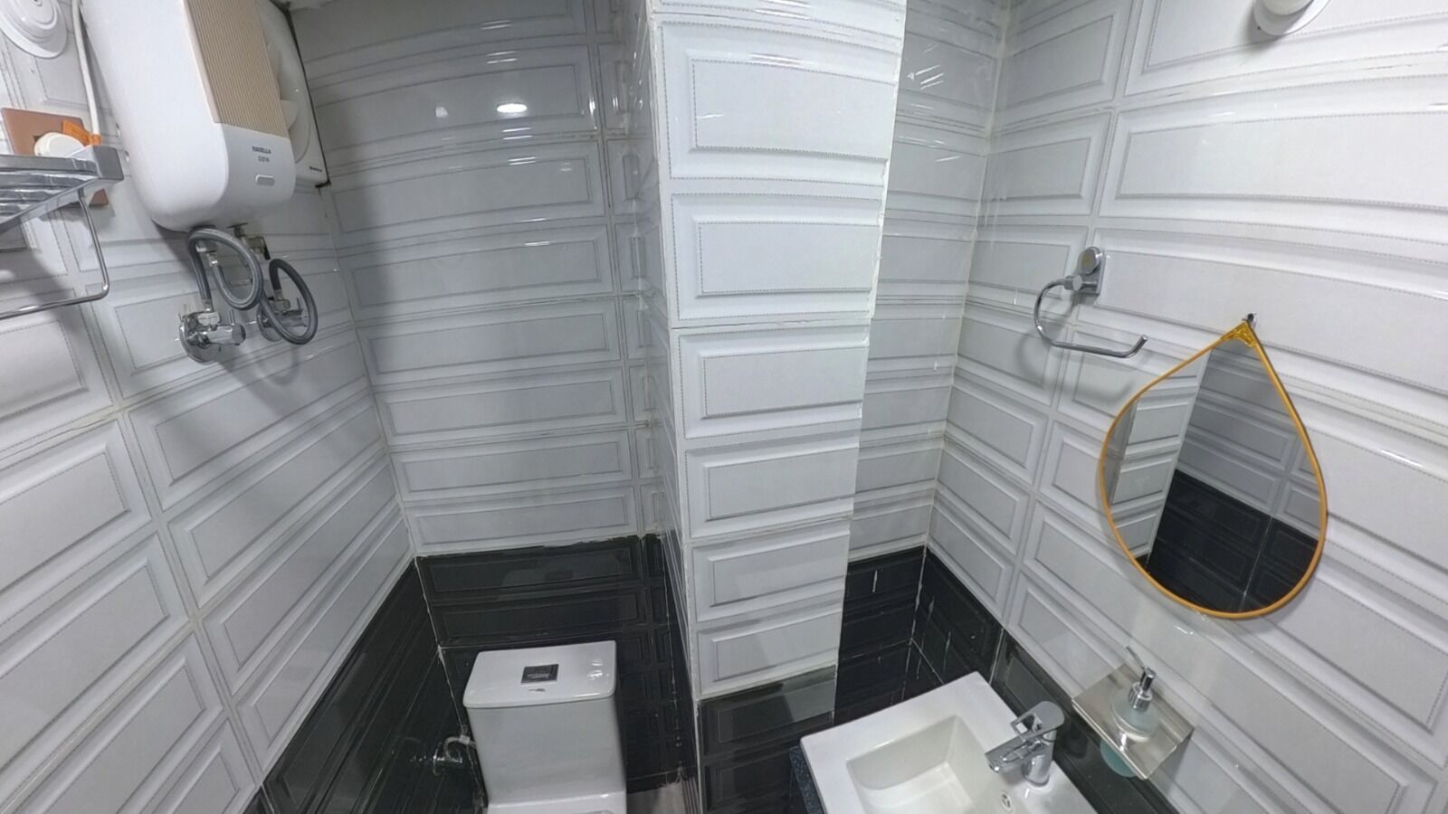 A bathroom with a toilet, sink, and mirror.