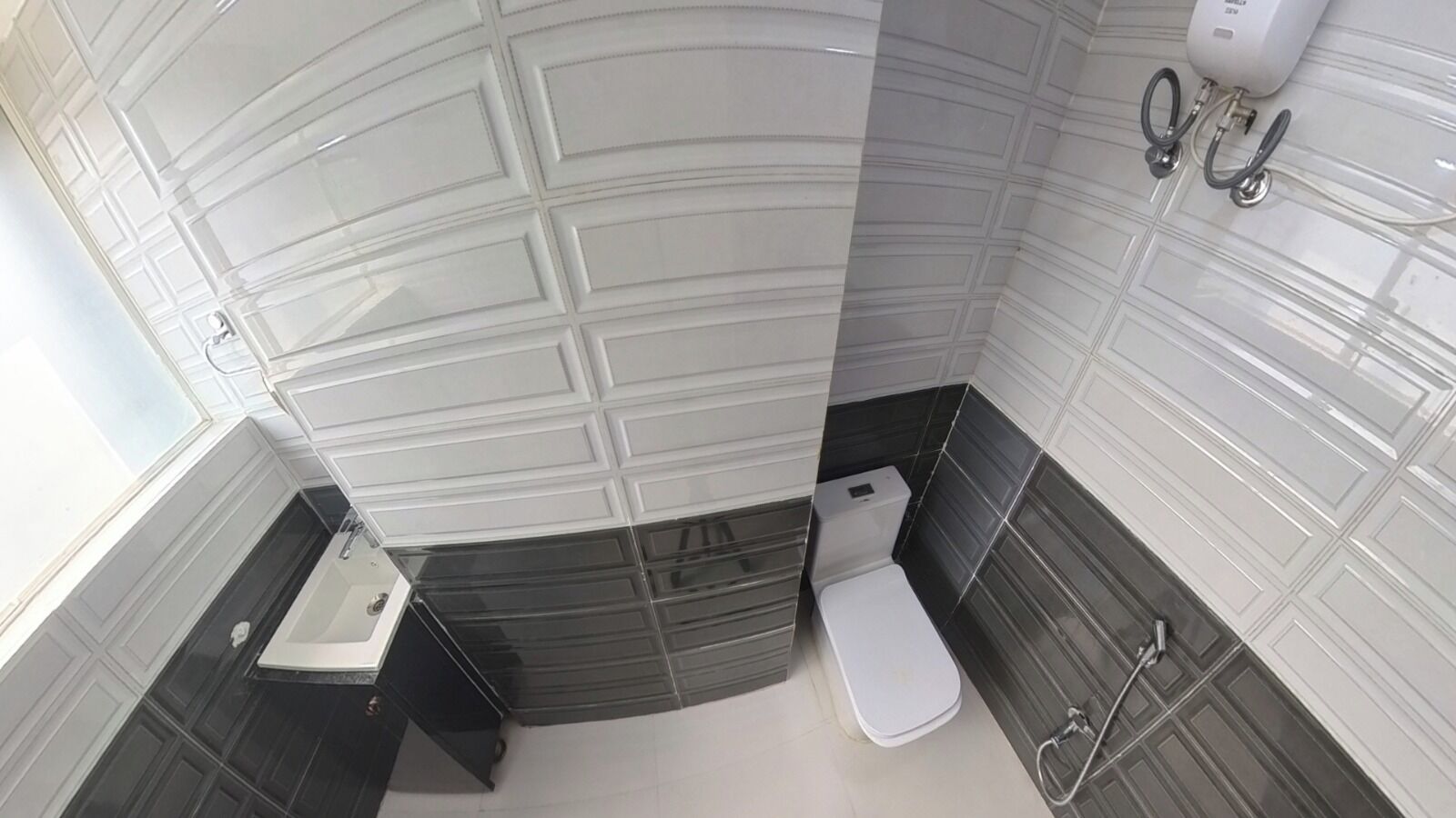 Une salle de bain comprenant des toilettes, un lavabo et un espace douche.