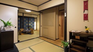 Ein traditioneller japanischer Raum mit Tatami-Bodenbelag, einem niedrigen Holztisch und einer Shoji-Schiebetür.