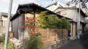 Ein traditionelles japanisches Haus mit Holzzaun, Betonfundament und Ziegeldach.
