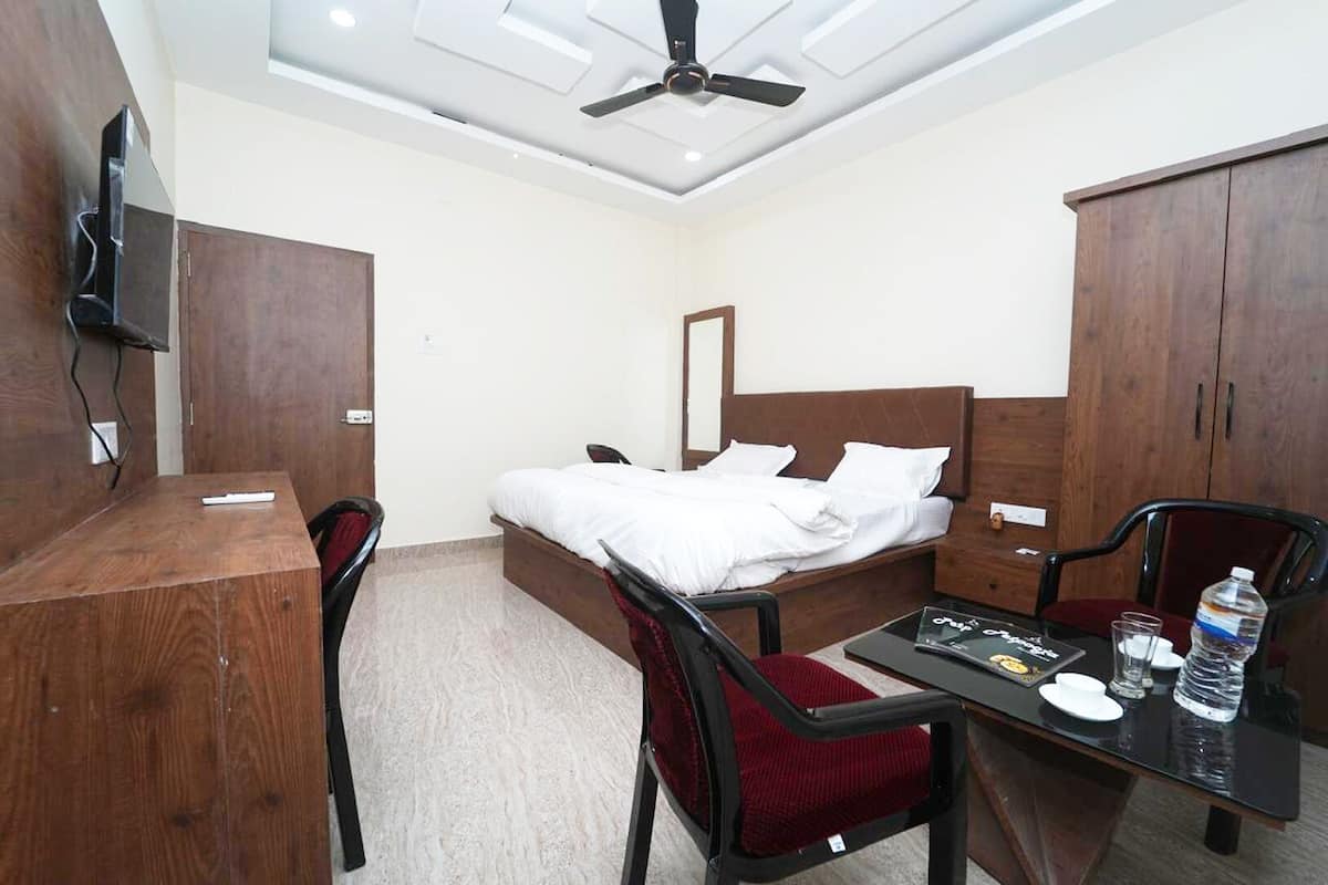Une chambre d’hôtel comprenant un lit, un bureau, une chaise, une table et une armoire.