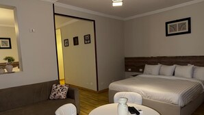 A modern bedroom with a bed, a sofa, a coffee table, and a mirror. - eco home suite (Giza)