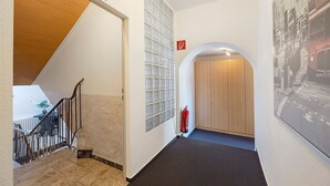 A hallway with a staircase, a fire extinguisher, and a door with a fire exit sign. - Room "Room 1" in Extertal (Extertal)