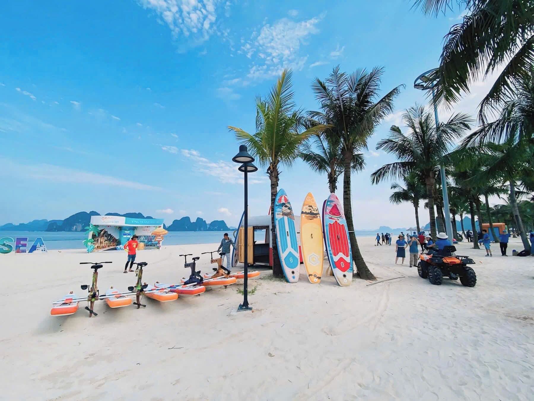 Una playa con tablas de surf, una bicicleta y un patinete.