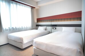 Ein Hotelzimmer mit zwei Betten, einer Minibar und einem Vorhangfenster.