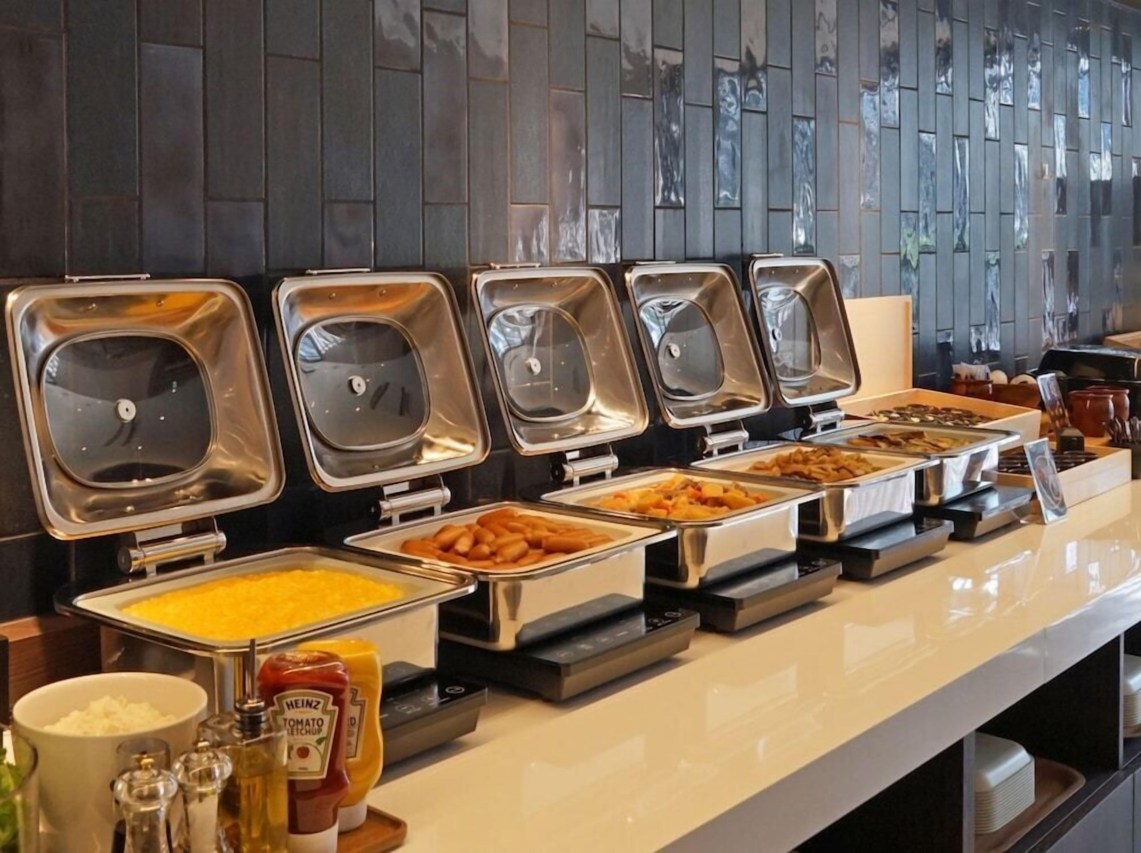 A buffet with various food items and condiments.