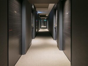 A corridor with doors on both sides, carpeted floor, and a ceiling with recessed lighting. - Chisun Standard Kyoto Horikawa Gojo (Kyoto)