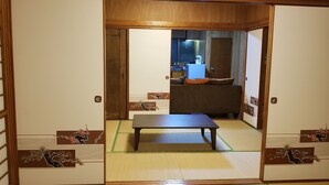 Een traditionele Japanse kamer met tatami vloerbedekking, een lage tafel en schuifdeuren.
