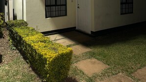 Un edificio con fachada blanca, una puerta y dos ventanas.