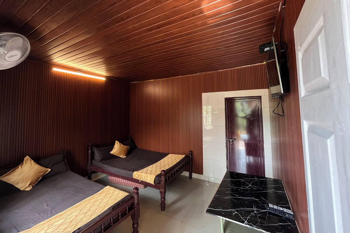 Une chambre avec deux lits, un plafond en bois, un sol carrelé et un comptoir en marbre noir.