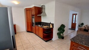 A kitchen with wooden cabinets, a stove, and a sink. - Relaxing country home half way between Gold Coast and Brisbane (Wolffdene)