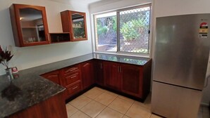 A kitchen with wooden cabinets, a stainless steel refrigerator, and a window with a view of greenery. - Relaxing country home half way between Gold Coast and Brisbane (Wolffdene)