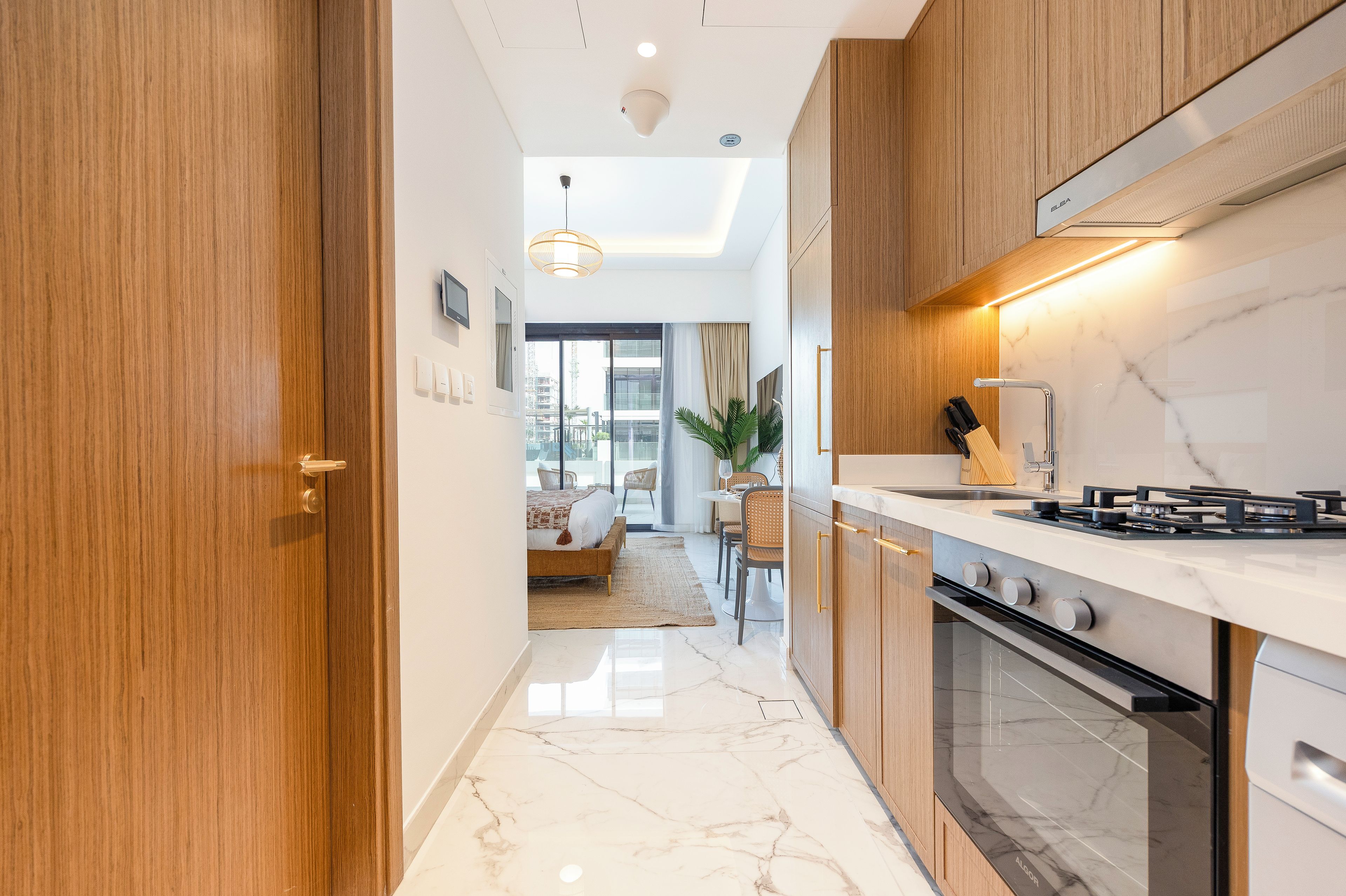 Une cuisine moderne équipée d’une cuisinière, d’un four et de meubles de rangement en bois.