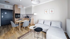A modern apartment with a dining area, kitchen, and living space.