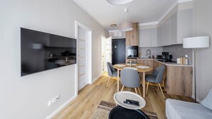 A modern apartment with a living room, dining area, and kitchen.