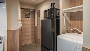 A compact kitchen with a black refrigerator, a microwave, and a white washing machine. - Apartment Hotel 11 Dotonbori 8 (Osaka)