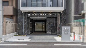 The entrance of Apartment Hotel 11 with a modern design, featuring a prominent entrance and a signboard. - Apartment Hotel 11 Dotonbori 8 (Osaka)