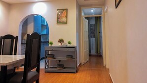Uma cozinha moderna com área de jantar, piso de madeira e um corredor que dá para um quarto.