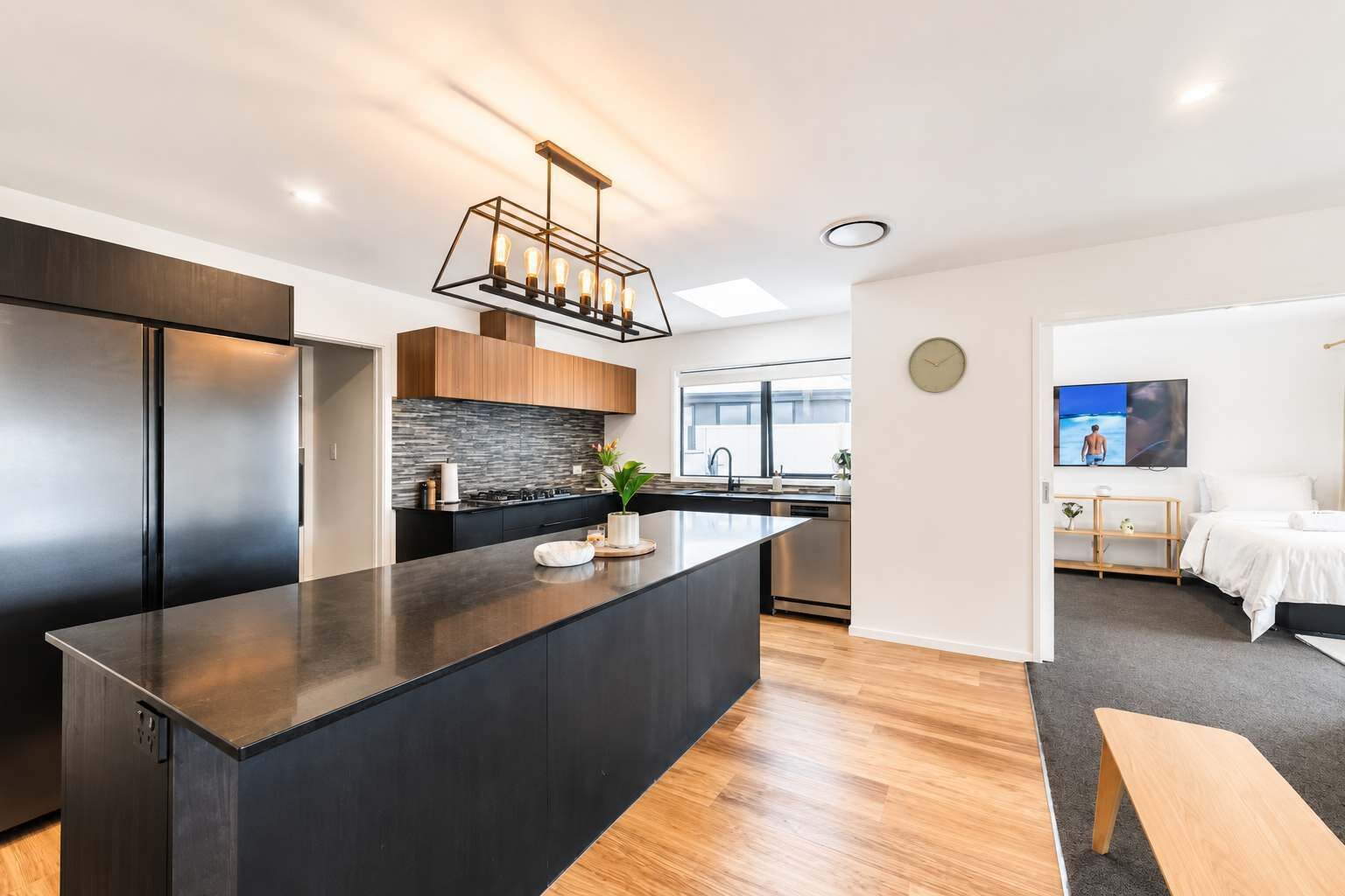 A modern kitchen with a central island, built-in appliances, and a contemporary light fixture.